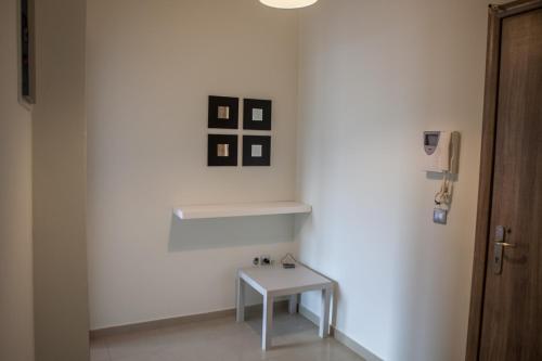 a white room with a table and some pictures on the wall at Lak Peristeri Homes 50m from metro station in Athens