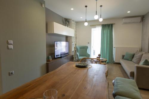 a living room with a wooden table and a couch at My Nafpaktos Resort in Nafpaktos