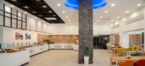 a lobby of a restaurant with tables and chairs at Hallim Resort in Jeju