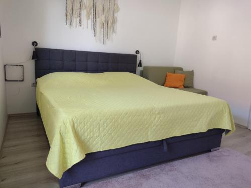 a bedroom with a large bed with a yellow blanket at Beautiful apartment with 2 terraces and a parking space in Kaštela