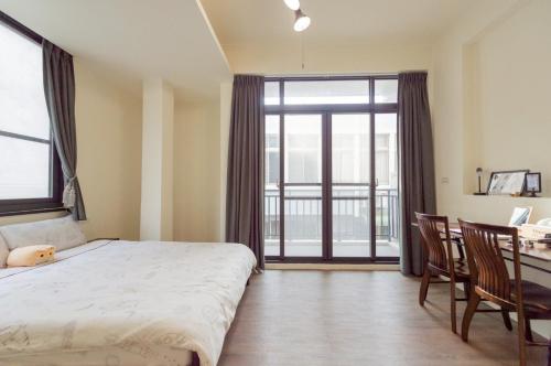 a bedroom with a bed and a desk and a window at 聽故事台南民宿 有貓的民宿 in Tainan