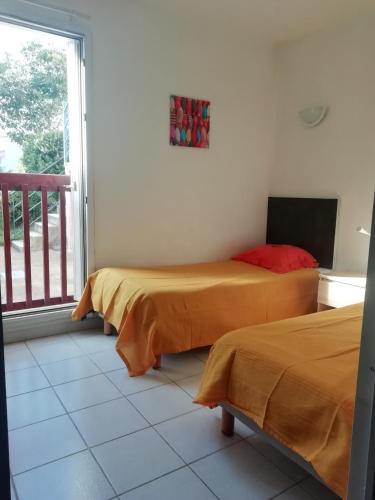 deux lits dans une chambre avec balcon dans l'établissement Les pieds dans l'eau !, à Cerbère