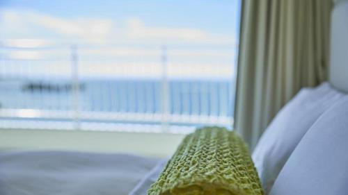 a room with a bed with a window and a tie at Hotel Harvest Nankitanabe in Tanabe