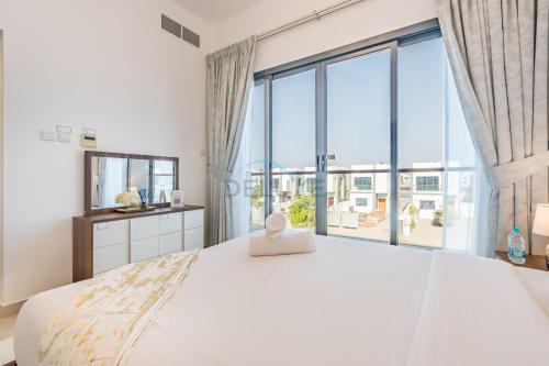 a bedroom with a large bed with a large window at Facing the Sea and Mountains 4BR Villa with Assistant Room and Private Pool, Al Dana Island, Fujairah by Deluxe Holiday Homes in Fujairah