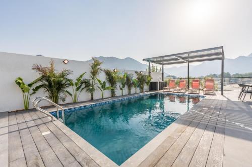 a swimming pool on top of a building at Facing the Sea and Mountains 4BR Villa with Assistant Room and Private Pool, Al Dana Island, Fujairah by Deluxe Holiday Homes in Fujairah