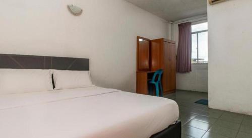 a bedroom with a large white bed and a window at OYO 89706 To-day Hotel in Sibu