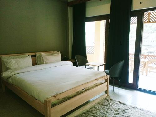 a bedroom with a bed and a large window at Bela Resorts Naran in Nārān