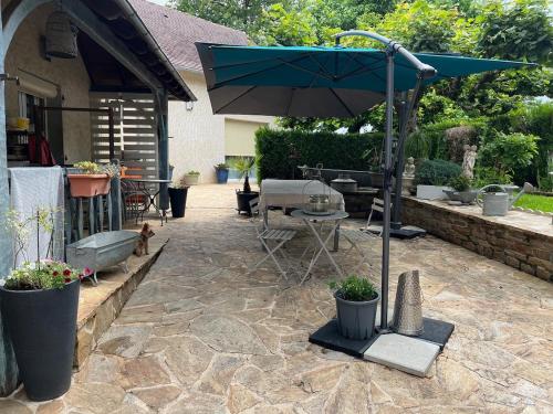 eine Terrasse mit Tisch und Sonnenschirm in der Unterkunft La Couade de Troche in Troche