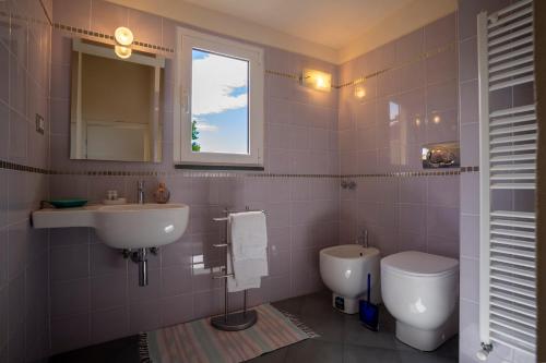 a bathroom with a sink and a toilet and a window at Affittacamere Pinuccia in Corniglia