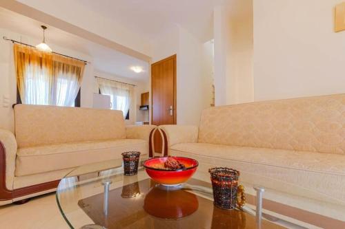 a living room with a couch and a bowl on a table at Heliophilia 3-bdrm Maisonette in Nea Fokea in Nea Fokea
