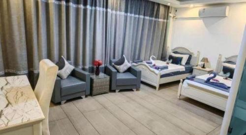 a living room with two beds and two chairs at Crystal Palace Hotel in Port Vila