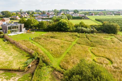 un champ de foin avec une ville en arrière-plan dans l'établissement Huis van Hout - architectenwoning met grote panorama tuin - design hot tub optioneel, à Herk-de-Stad