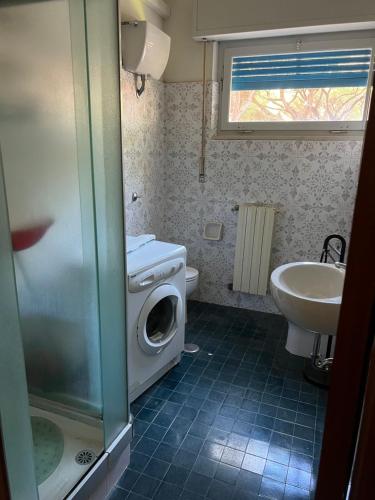 a bathroom with a washing machine and a sink at Residenza tra i Pini in Marina di Grosseto