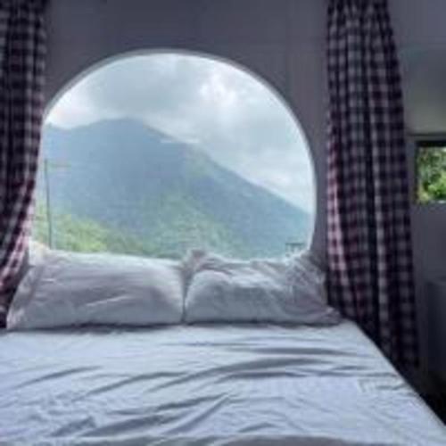 a bedroom with a bed with a large window at Roses Homestay- Venuestay in Tam Ðảo