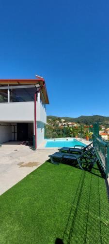 a view of a swimming pool with a green lawn at Casa do Vale in Arcos de Valdevez