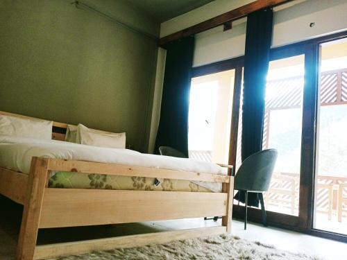 a bedroom with a bed and a large window at Bela Resorts Naran in Nārān