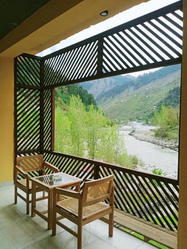 a balcony with two chairs and a table and a view at Bela Resorts Naran in Nārān
