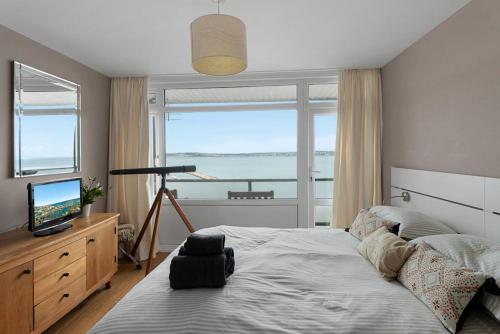 Un dormitorio con una cama con vista al mar. en Seaside Rendezvous - Sleeps 7, Sea Views & Parking, en Brixham