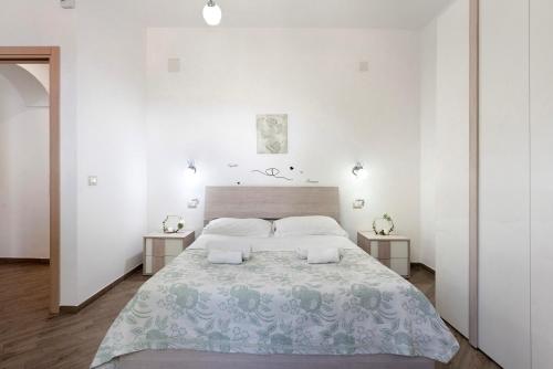 una camera bianca con un grande letto con due tavoli di Bella veduta Luna ad Agerola