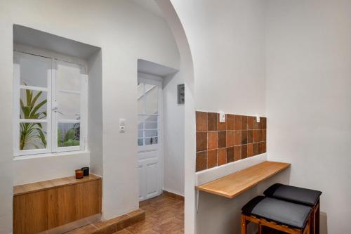 um corredor com um banquinho e um banheiro com paredes brancas em Grand Haven - New Renovated Spacious Apts in Prime Location em Atenas