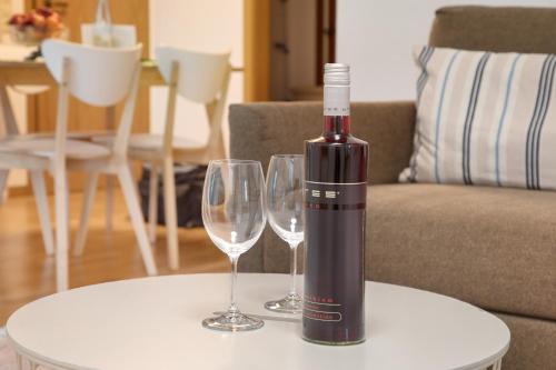 a bottle of wine sitting on a table with two wine glasses at Haus Am Sonnenhügel in Bad Urach