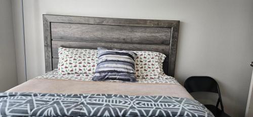 una cama con cabecero de madera y dos almohadas en Furnished Executive 3-bed 2-bath Apartment Wichita Kansas, en Wichita