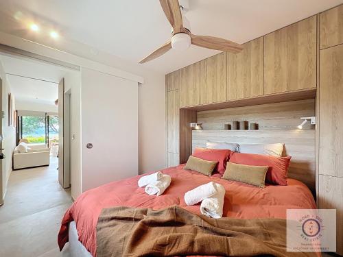 une chambre avec un grand lit avec des draps et des oreillers rouges dans l'établissement Gigaro POSÉIDON VUE MER, à La Croix-Valmer