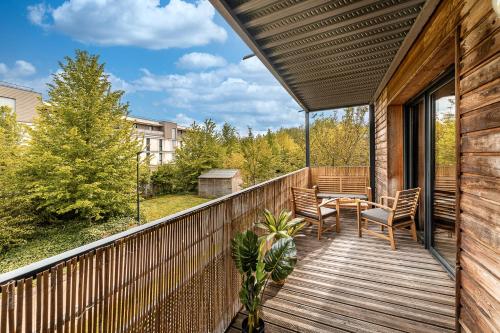 - un balcon en bois avec une table et des chaises dans l'établissement Le Repaire de Simba - Near DIsneyland Paris, à Montévrain