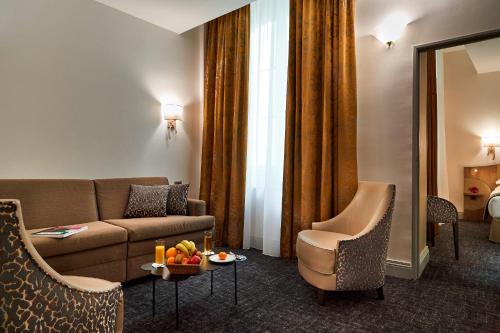 a living room with a couch and a table with fruit on it at Best Western Premier HBEO Bordeaux Centre in Bordeaux