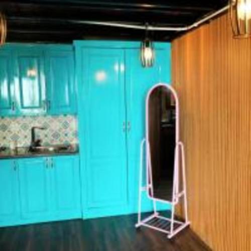 a kitchen with blue cabinets and a chair in it at Roses Homestay- Venuestay in Tam Ðảo