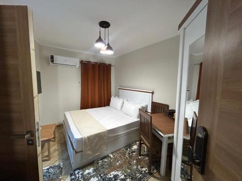 a bedroom with a bed and a desk and a mirror at Stayline hotel apartments 5 mins from Cairo airport in Cairo