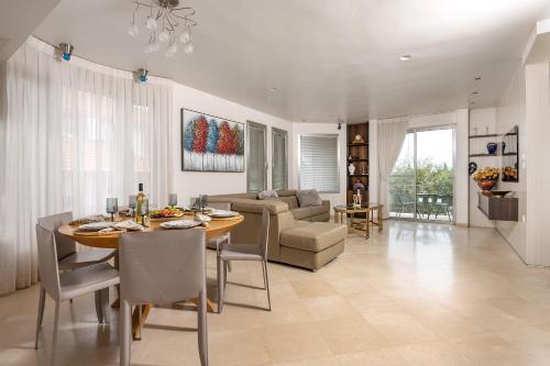 a dining room and living room with a table and chairs at Tel Mond Complex - וילה מקסימה למשפחות וסוויטה in Tel Mond