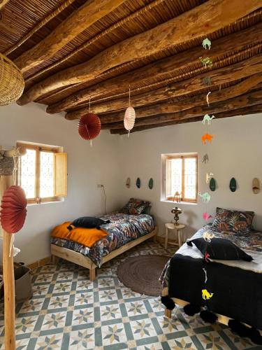 Dos camas en una habitación con techos de madera. en Lalla Rose, en Lalla Takerkoust