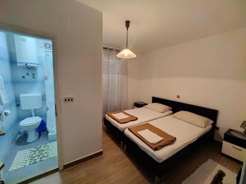 a bedroom with a bed and a bathroom with a shower at Apartments Stana in Sukošan