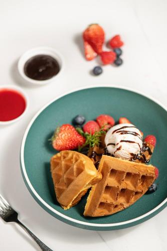 a green plate with waffles and ice cream and strawberries at Grand Hyatt Shenzhen in Shenzhen