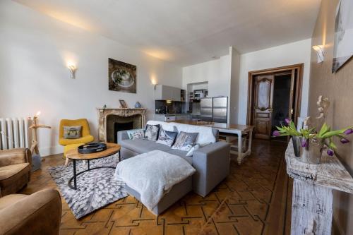 un salon avec un canapé et une cheminée dans l'établissement Dans château des magnans, grand appartement 10 couchages, à Jausiers