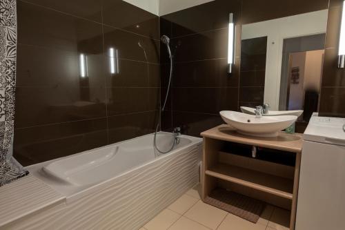 une salle de bain avec un lavabo et une baignoire et un lavabo dans l'établissement Dans château des magnans, grand appartement 10 couchages, à Jausiers