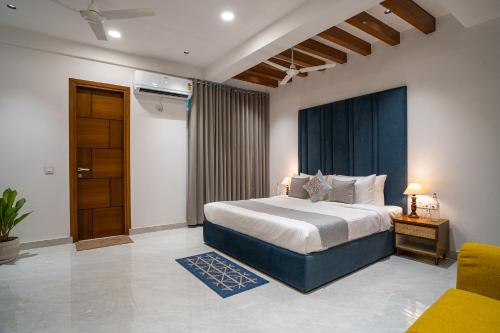 a bedroom with a king sized bed and a chair at Alaya Stays Udgam Vilas Serene 5-BHK Apartment With Jacuzzi & Lift in Dehradun