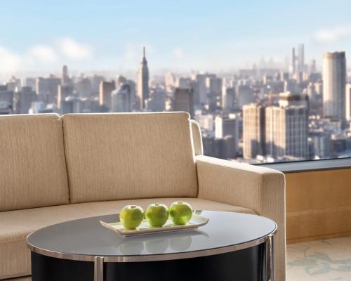 a couch with a table with a plate of apples on it at Shangri-La Nanjing in Nanjing
