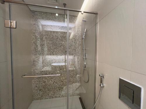 a shower with a glass door in a bathroom at Stylish Studio in Mayan 2, Yas Island in Abu Dhabi