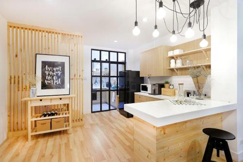 una cucina con piano di lavoro bianco e armadi in legno di Vélin - Samsen a Bangkok