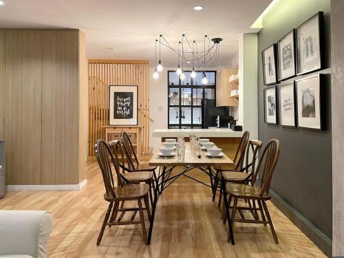 una sala da pranzo e una cucina con tavolo e sedie di Vélin - Samsen a Bangkok