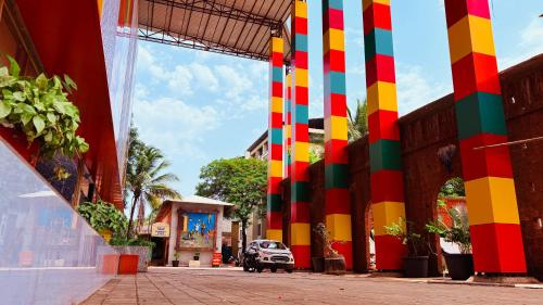 a car is parked in front of a building with colorful columns at Hotel Sai Palkhi Niwara in Shirdi