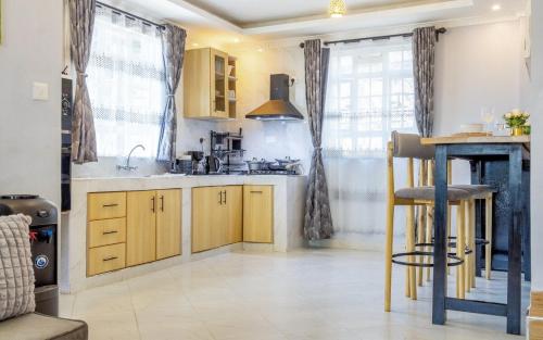 a kitchen with wooden cabinets and a table in it at The Cabin Azure in Naivasha