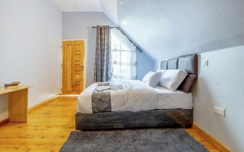 a bedroom with a bed in a room with a window at The Cabin Azure in Naivasha