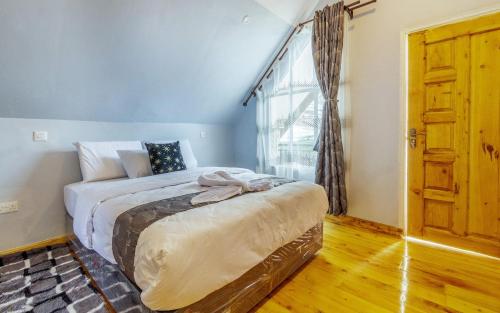 a bedroom with a bed and a large window at The Cabin Azure in Naivasha