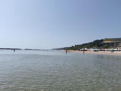 a beach with people standing in the water at Casa Mayra in Campofilone