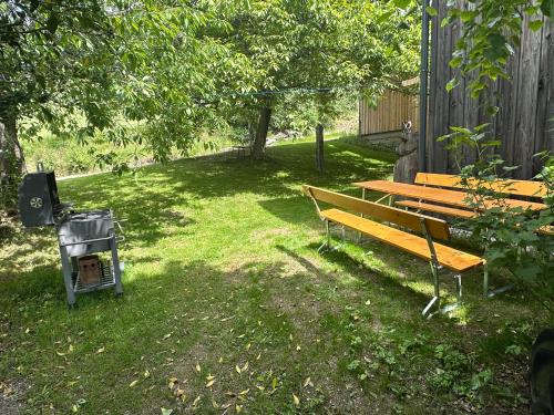 a park bench sitting in the grass next to a grill at Ferienwohnungen Hatzl in Neuwald