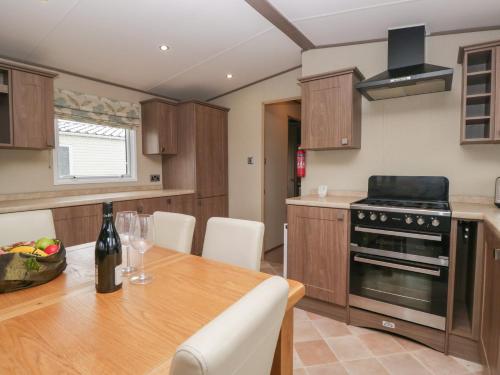 a kitchen with a wooden table with a bottle of wine at Aspen in Denny