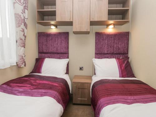 two beds sitting next to each other in a room at Aspen in Denny